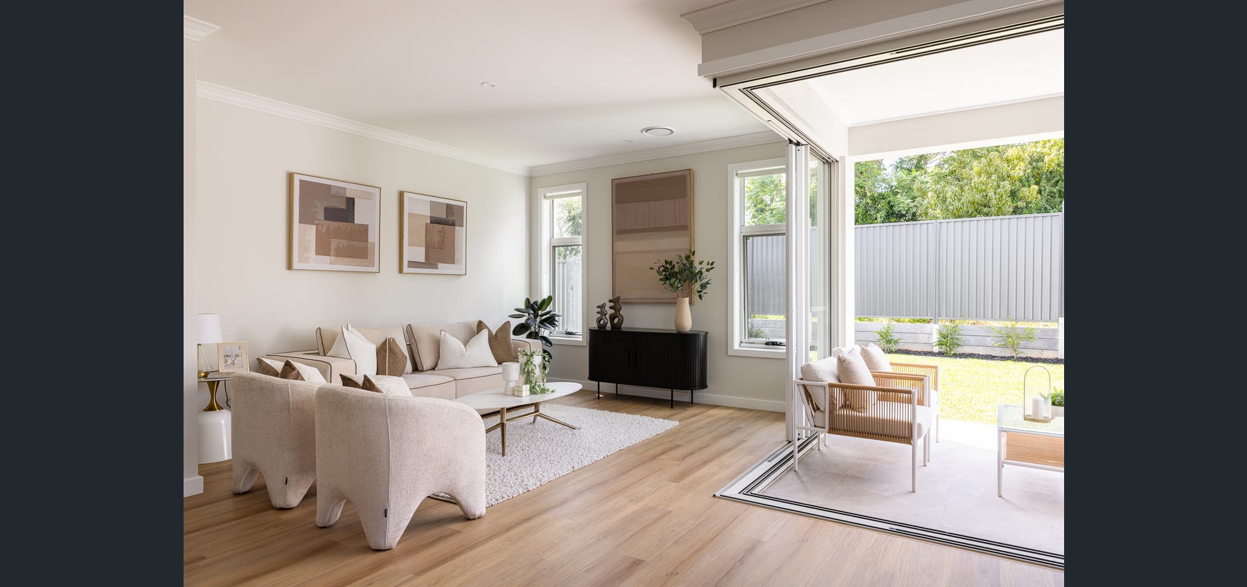 Open-plan living room opening to a covered outdoor area