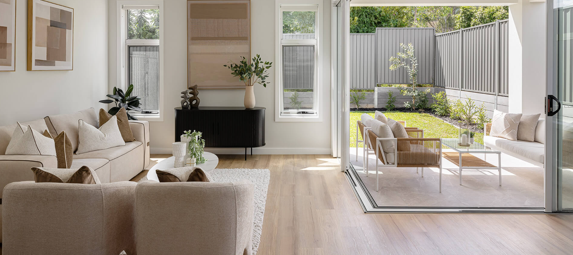 Completed living room opening to a covered entertaining area and private garden at The Honours Norwest