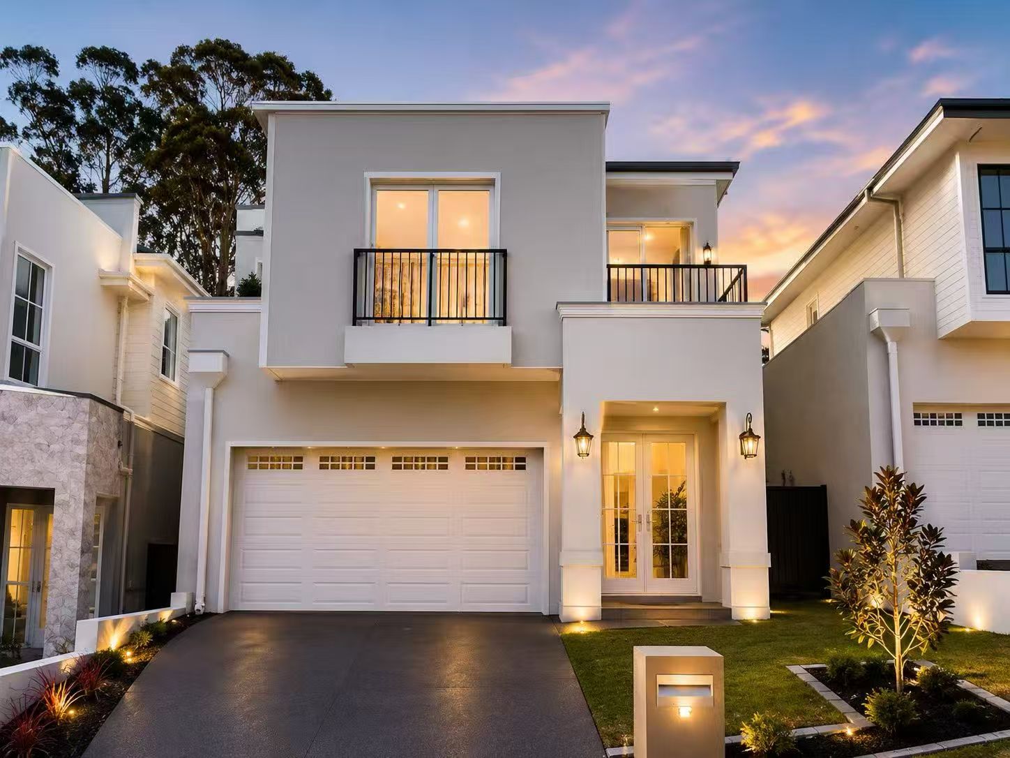 Contemporary white residence illuminated at dusk