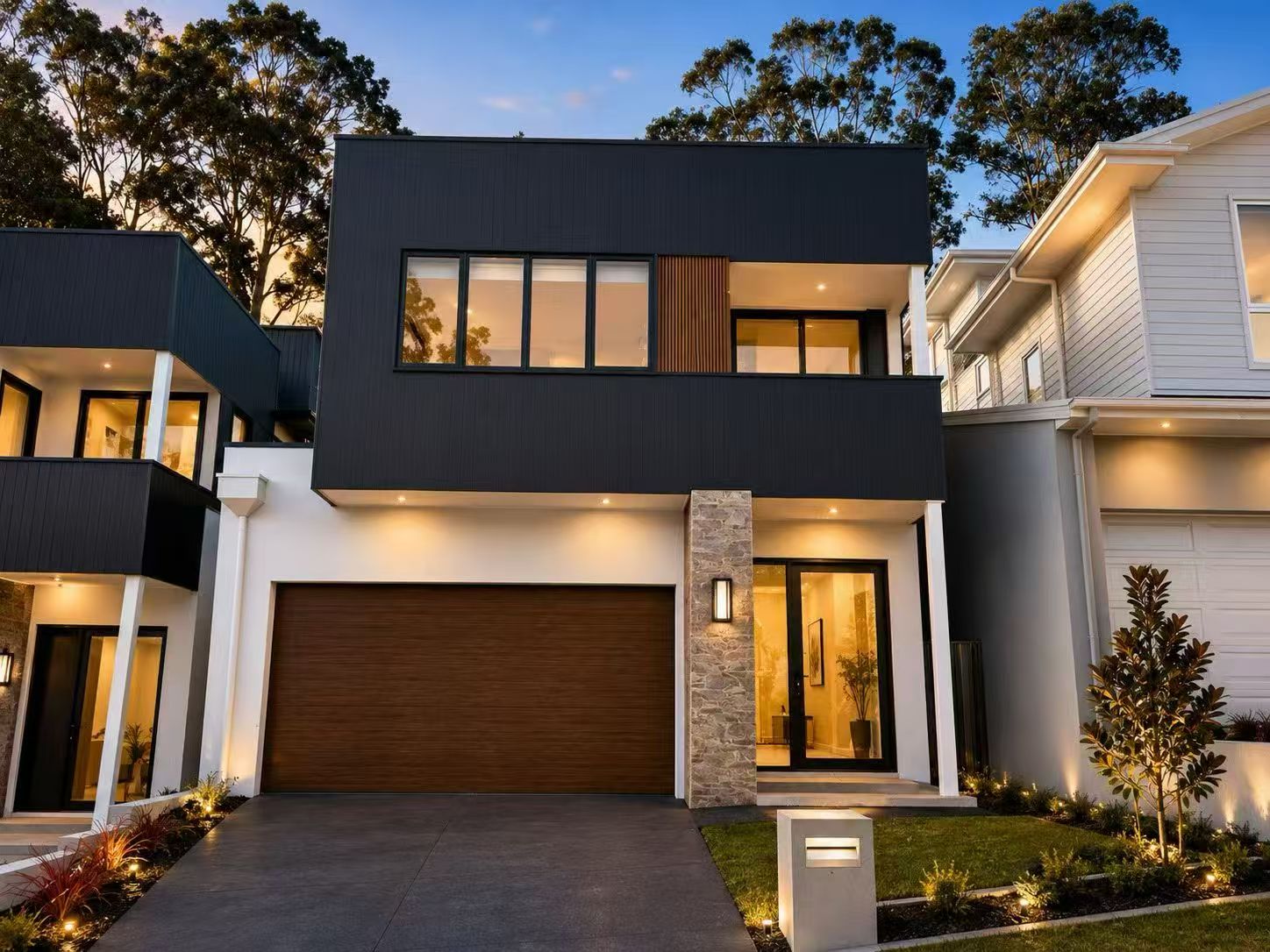 Modern dark-facade residence illuminated at dusk